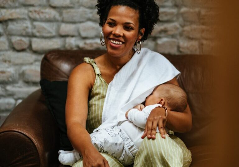 Portrait of an african american woman breastfeeding her baby.